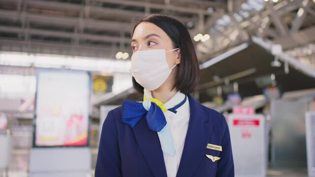 Close-up shot of flight attendant wearing face mask in the airport.