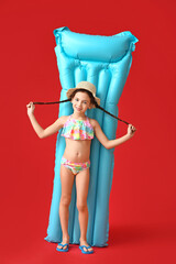 Cute little girl with inflatable mattress on color background