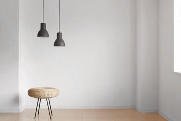 Pouf and lamps near light wall in room