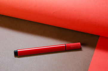 Creative minimalist composition with a red felt-tip pen on a two-color background.