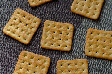 Salted crispy crackers on a gray textured surface.