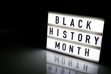 Lightbox with text BLACK HISTORY MONTH on dark black background with mirror reflection. Message...