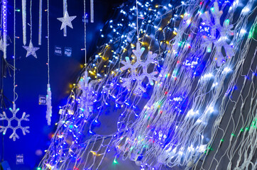 Electric garlands glowing on the counter of the store. Small lamps for sale. Christmas lights.