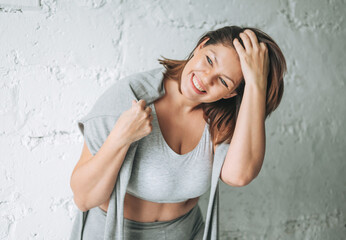 Beautiful happy emotional brunette young woman plus size body positive in comfortable sport wear...