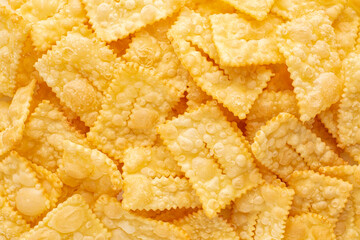 Background with sfrappole or chiachiere or angel wings. Traditional sweet crisp pastry deep-fried. Top view.