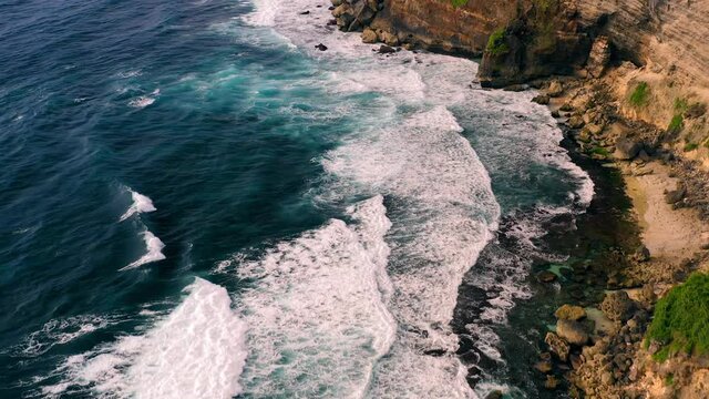Majestic cliffs at Karang Boma with waves crashing on shore of Bali, aerial