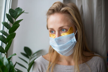 Woman doing facial treatments. Anti-wrinkle patches. During a pandemic, a woman is forced to wear a...