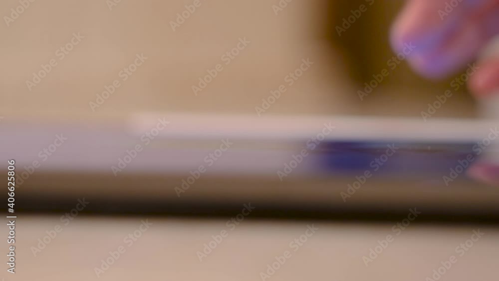 Poster close-up of man using tablet at table. concept. person uses new tablet on blurry background. person 