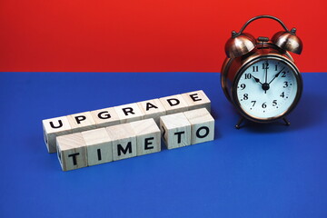 Time to Upgrade alphabet letter with alarm clock on blue and red background