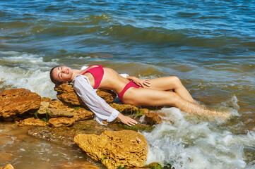 Young woman in white shirt and swimsuit at sea resort