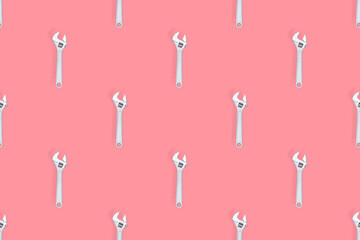 Adjustable metal wrench seamless pattern. Adjustable metal wrench on a colored background.