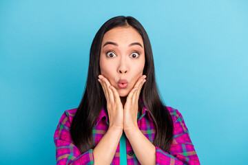 Photo of astonished young girl hands on cheeks cant believe purple checkered clothing isolated on...