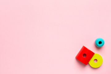 Colorful wooden constructor for children. Preschool education concept with details, screwdriver and screws on pink background with copyspace