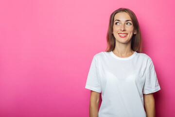 Young woman in a white t-shirt looks to the side on a pink background. Banner
