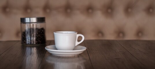 Fototapeta na wymiar Hot coffee in a white mug on a dark wood table in a cafe
