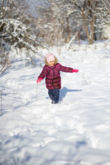 Fototapeta na wymiar A child girl on a walk in a winter park