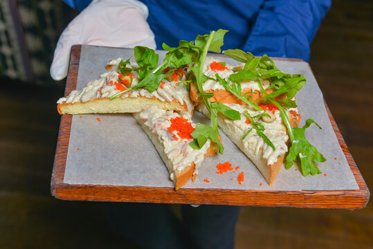 Pie with cheese and caviar served in a restaurant or diner. Waiter service, eating out concept.