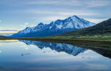 Naklejka na ściany i meble Mountains reflecting in a lake in the blue hour before sunrise