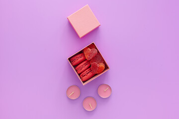 Valentine's day concept. Pink box with marmalade and gift macaroons and a beautiful rose on a pink background