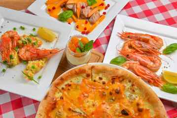 Italian cuisine concept flat lay, top view. Persimmon dishes menu, pizza, shrimps, salad, dessert.