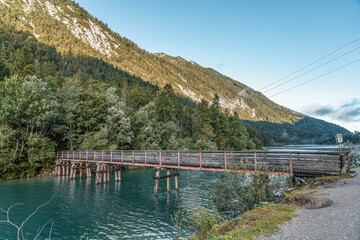 Fototapeta na wymiar Wooden bridge over Plansee lake in Austria morning