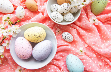 Obraz na płótnie Canvas Easter eggs on pink polka dot background with spring cherry blossom