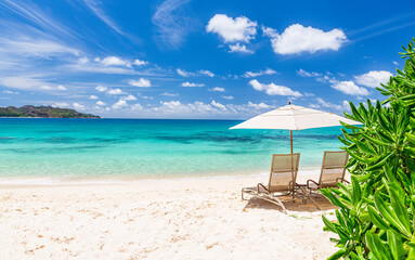 Two beach chairs and white umbrella on Idyllic tropical sandy beach, Seychelles