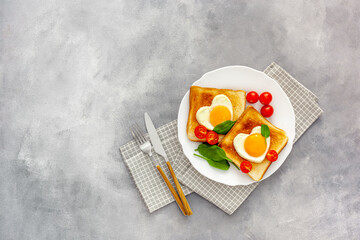 Scrambled eggs in the form of heart on plate with tomatoes, greens and coffee