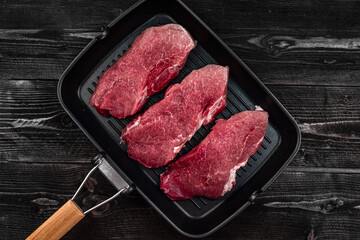 three juicy pieces of meat - barbecue cooking steak in a pan