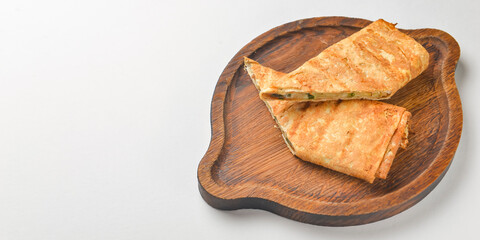 Lavash with suluguni cheese inside. Delicious snack. Served on a wooden board over white background.