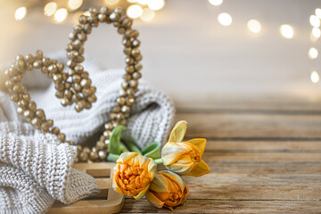 Cozy home composition for Valentine's Day with a decorative heart and flowers close up.