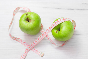 Measuring tape wrapped around two green apple isolated on white background, Concept of the goal to lose weight,the goal of diet