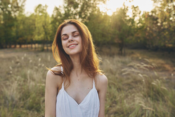 Naklejka premium happily traveler resting in a field in nature and trees in the background gesturing with her hands