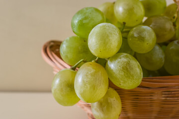 Detail of green grape bunch in a wicker basket.