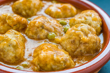 Meatballs in sauce in a clay pot.	
