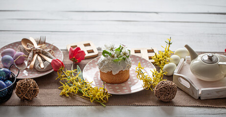 Easter composition with cake, tea, flowers, eggs and decoration details.