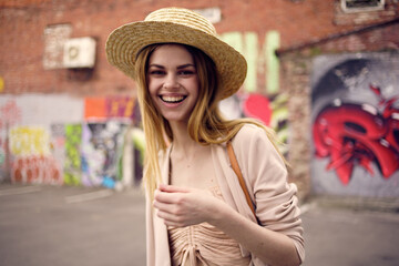 Cheerful woman with hat outdoors urban style graffiti outdoors