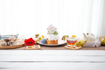 Festive Easter cake on the table among flowers and other details copy space.