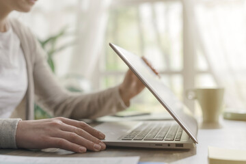Woman sitting at desk and working with her laptop