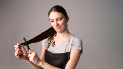 Naklejka premium Attractive hairdresser woman with professional tools in her hands