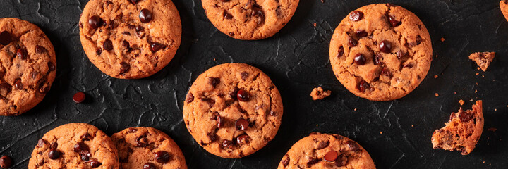 Chocolate chip cookies panorama on a black background, shot from above