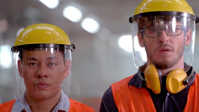 portrait of worker men wearing face shield mask to safety face and prevent contamination of pollution and disease virus outbreak. New normal life of factory operation life in workplace industrial.