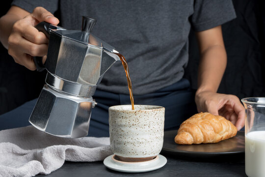 Close-up Professional Of A Barista Using Italian Moka Coffee Pot Poured Espresso. Making Hot Coffee With Croissant Bread And Equipment, Tool Brewing On The Bar At Kitchen Home