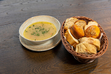 Chicken soup served with bread on a wooden table