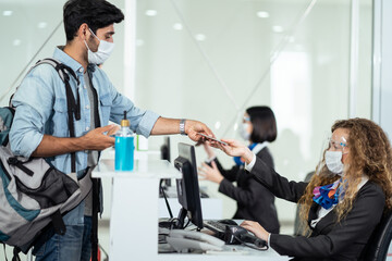 Fototapeta premium Caucasian male passenger handing passport to airline staff to check-in