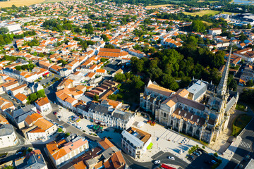 Obraz premium Aerial view of Lucon Cathedral of Notre Dame of Assumption on background of townscape on summer day, Vendee, France..