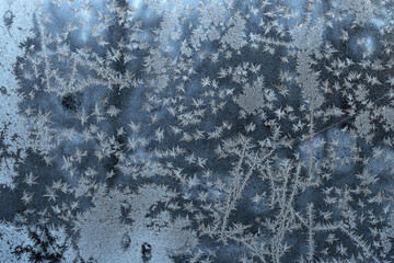 Beautiful winter background with frozen glass and white snowflakes