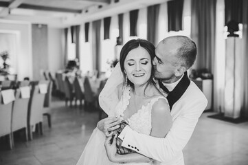 First dance. Happy stylish bride and groom dancing and having fun at wedding reception in...