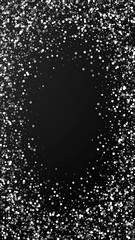 Obraz premium Random white dots Christmas background. Subtle flying snow flakes and stars on black background. Actual winter silver snowflake overlay template. Extraordinary vertical illustration.