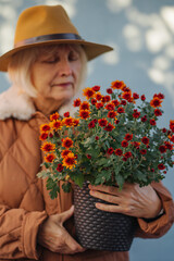 Stylish senior lady with flowerpot